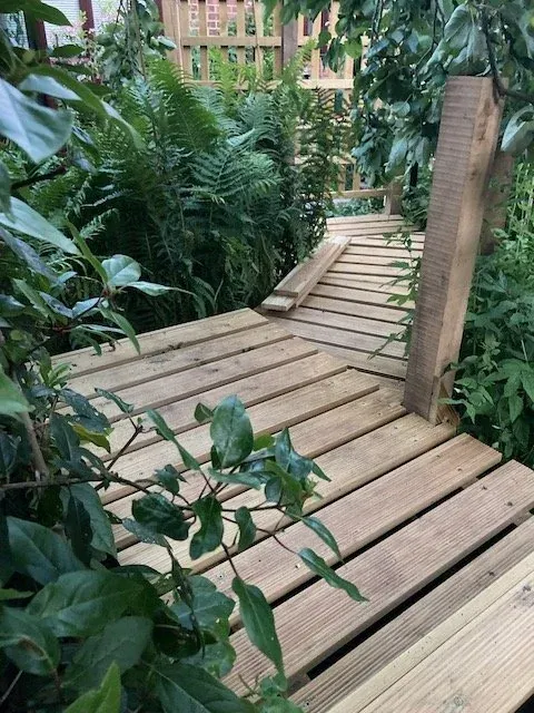 Raised timber deck and walkway built through a mature garden